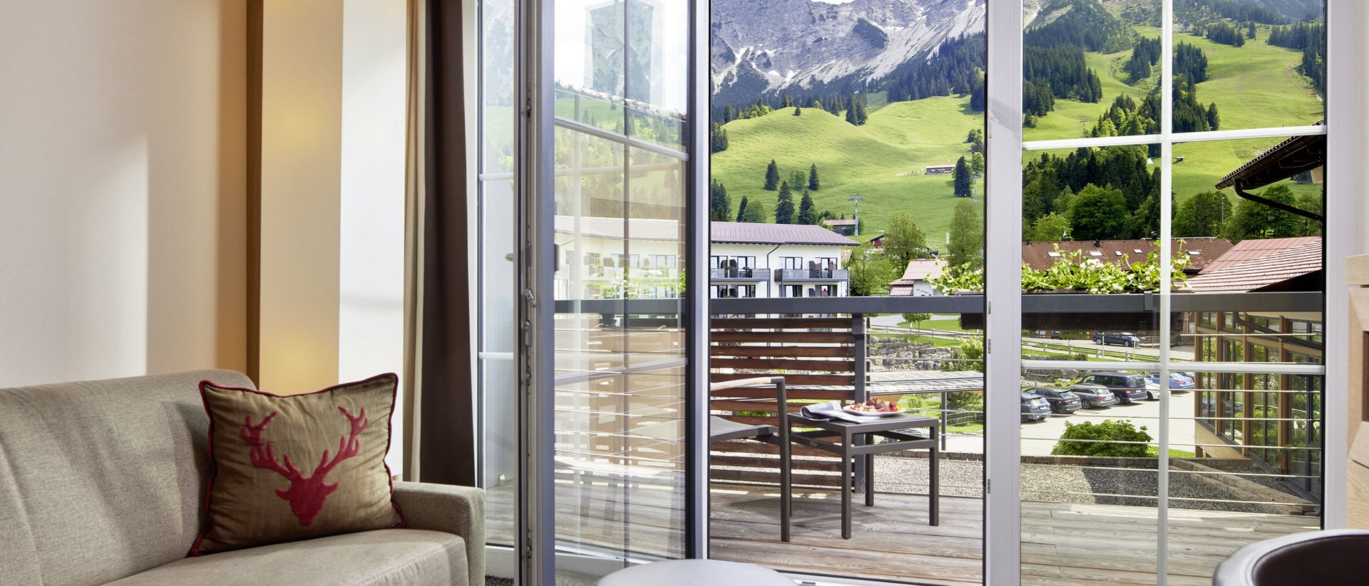 Autofrei in Das Weitblick Allgäu reisen Wohnzimmer mit Sofa und Balkon mit Bergblick