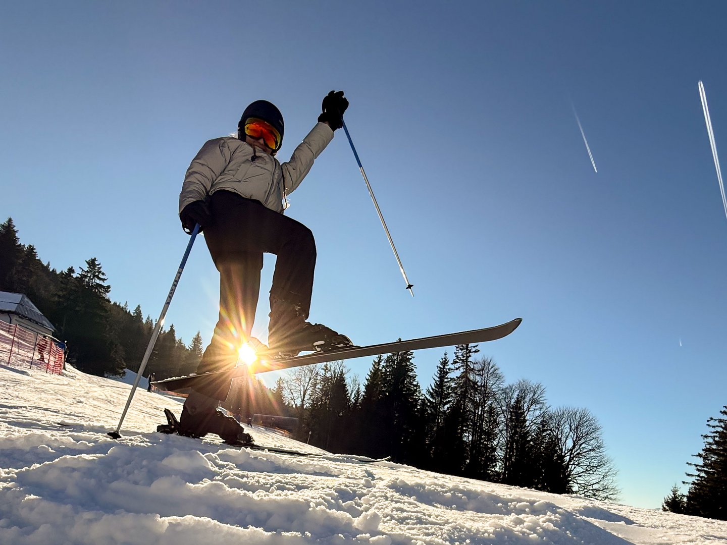 Skifahren lernen im Herzen des Allgäus Skifahrer hebt einen Ski bei sonnigem Wintertag auf schneebedecktem Hang