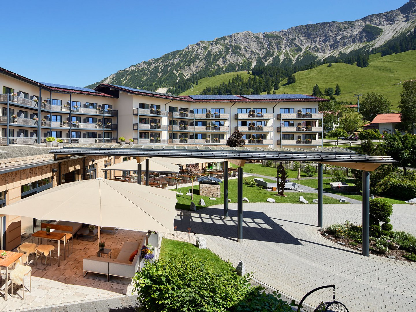 Veranstaltungen im Panoramahotel Oberjoch Hotel mit Terrasse, Sitzbereichen und Bergblick bei klarem Himmel