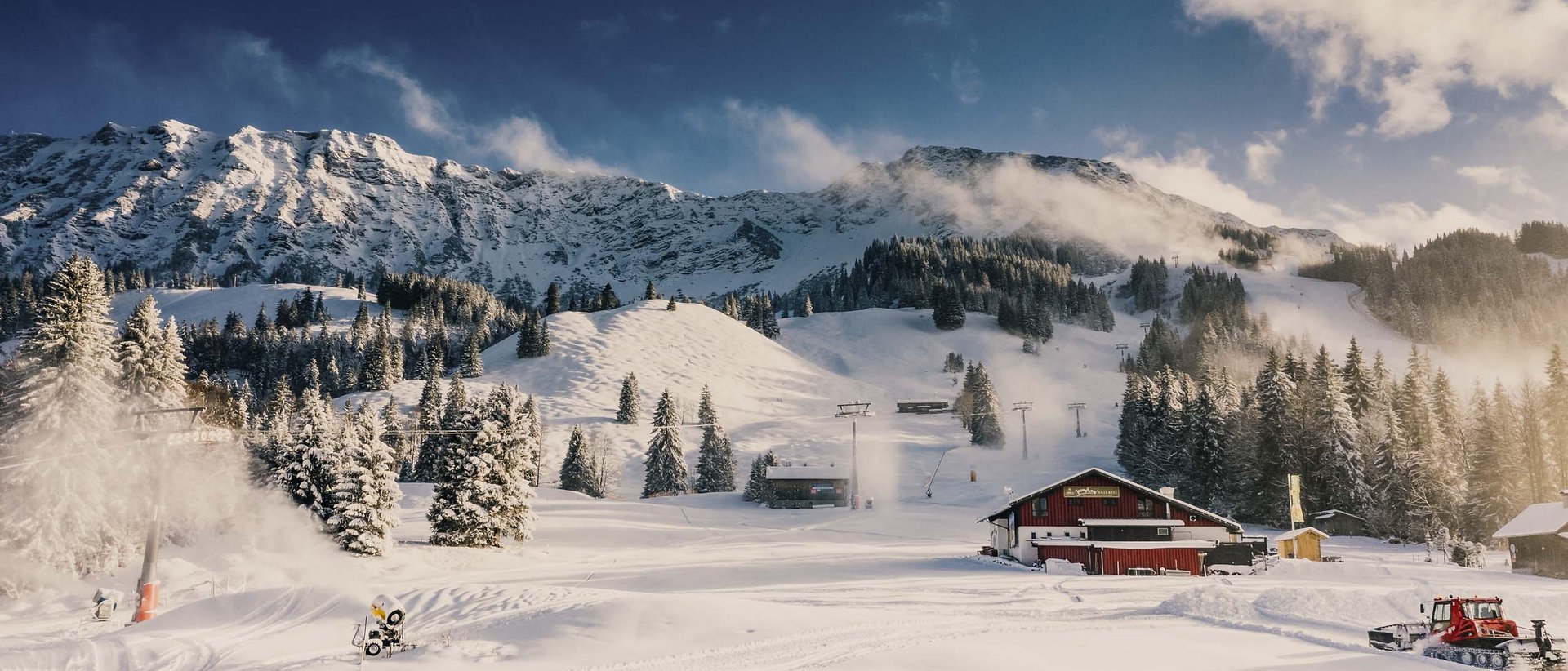 Skifahren lernen im Herzen des Allgäus Schneebedeckte Berge und Bäume mit einer Hütte und Skilift im Winter