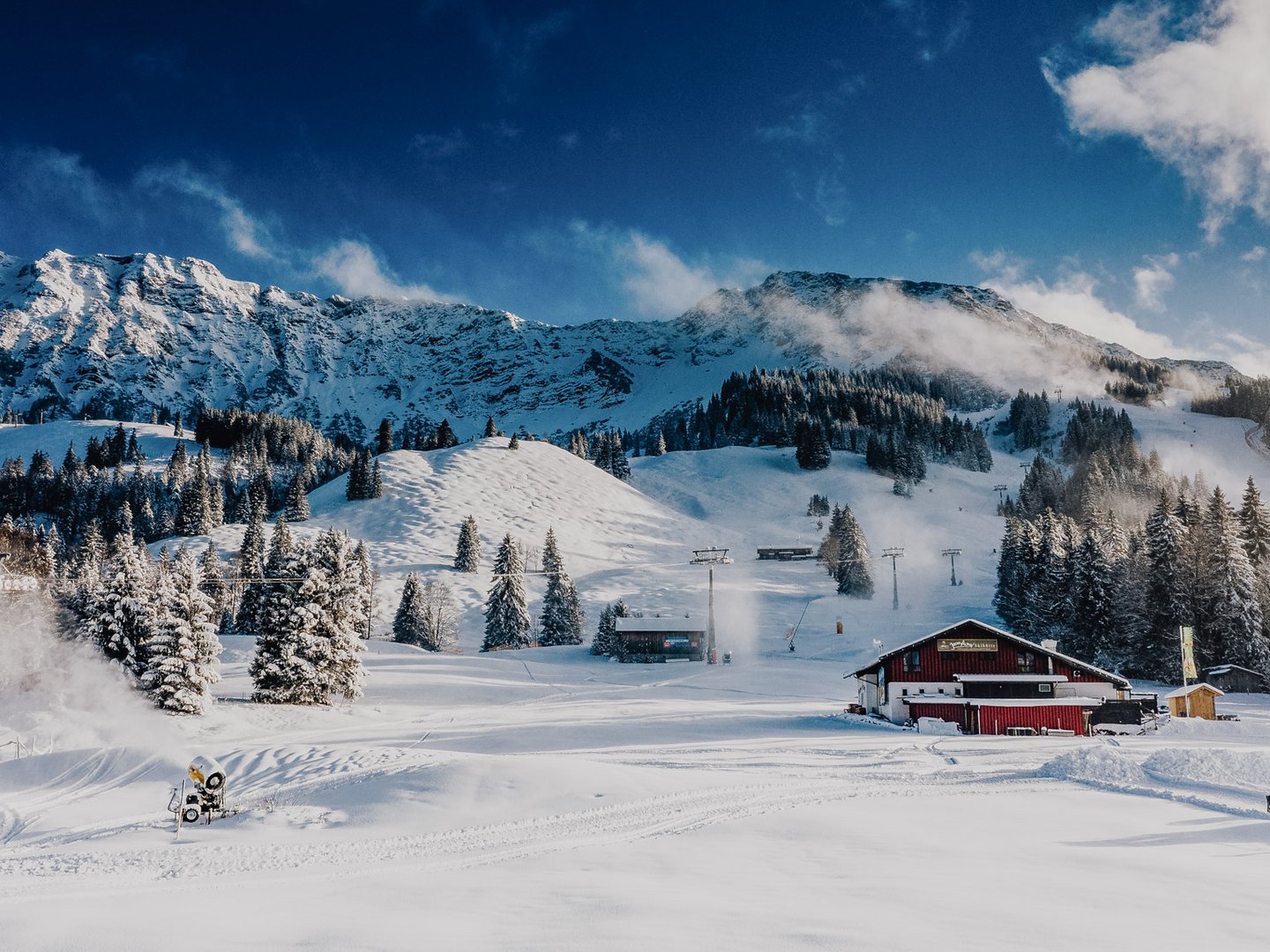 Veranstaltungen im Panoramahotel Oberjoch Verschneite Berglandschaft mit Skihütte, Bäumen und blauem Himmel
